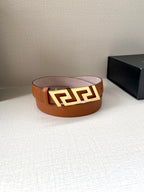 Orange leather belt with gold-tone buckle and logo motif; flat front view.