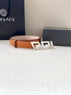Orange and blush leather belt with gold-tone logo buckle and single keeper holes.