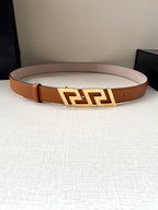 Orange leather belt with gold-tone logo buckle centered across the strap.