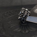 Silver-tone floral filigree ring with rhinestone accents, side view.