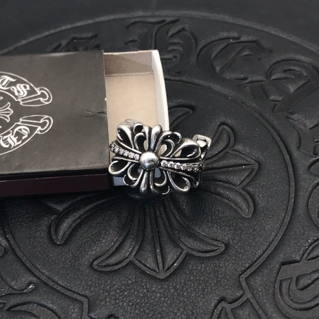 Silver-tone filigree flower ring with small sparkle bar detail.