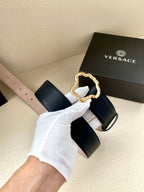 Dark blue leather belt with gold-tone ornate logo buckle