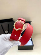 Red leather belt with gold Medusa-style buckle and punched adjustment holes