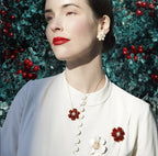 Woman wearing white flower earrings and a matching gold necklace with flower pendant