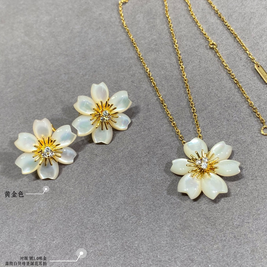 Gold chain necklace with white flower pendant and matching white flower stud earrings