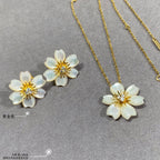Gold chain necklace with white flower pendant and matching white flower stud earrings