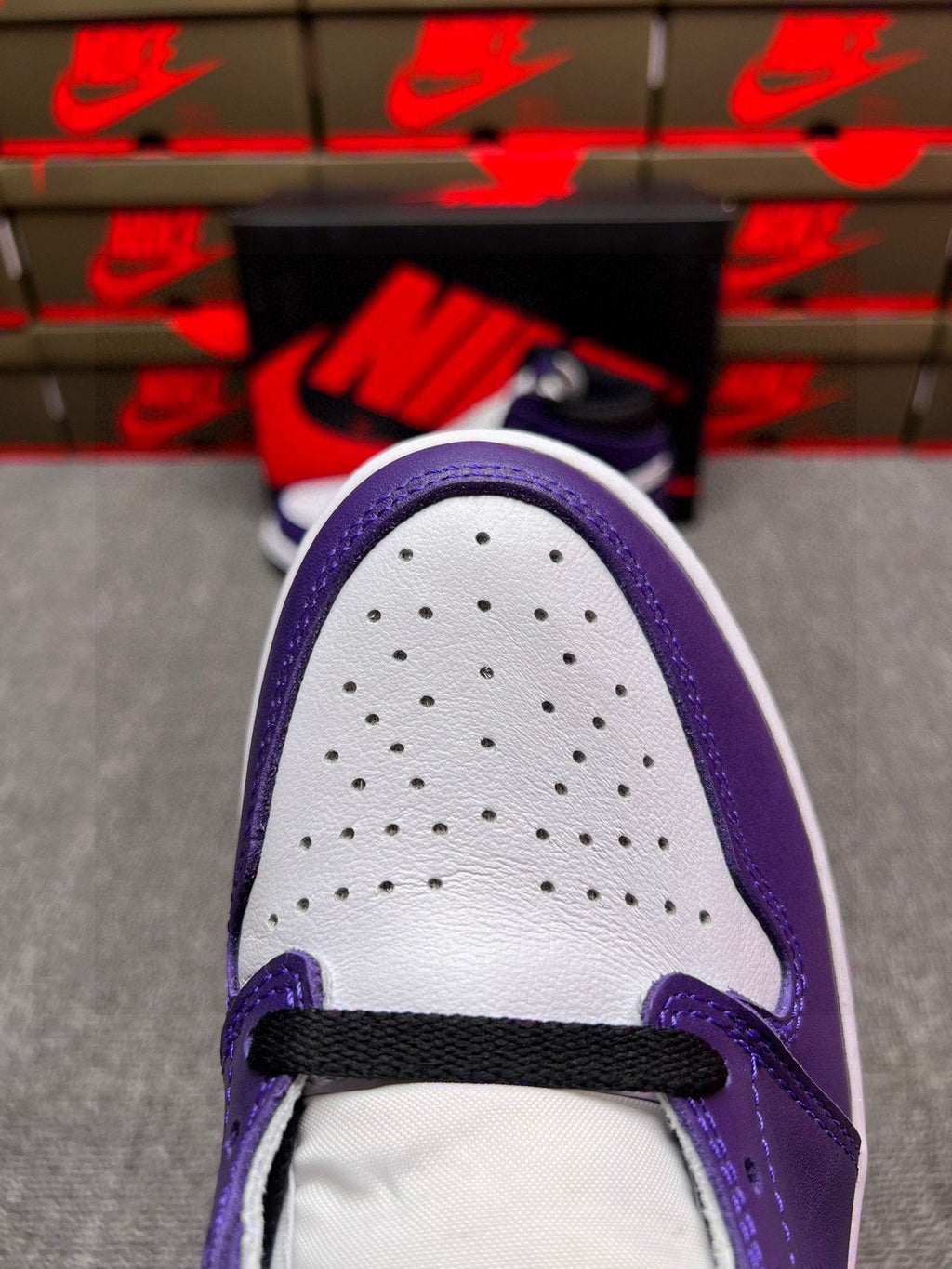 High-top sneaker toe box, white perforated leather with purple overlays and black strap