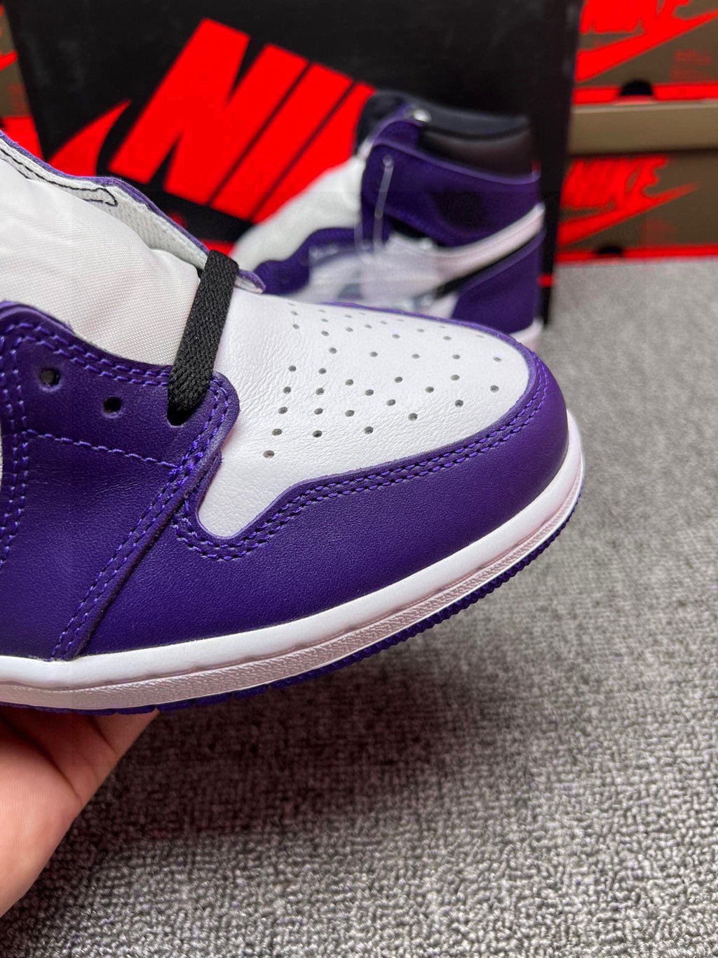 High-top sneaker side close-up with purple-and-white panels, black strap detail
