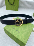Black leather belt with gold-tone double G buckle and round center emblem.
