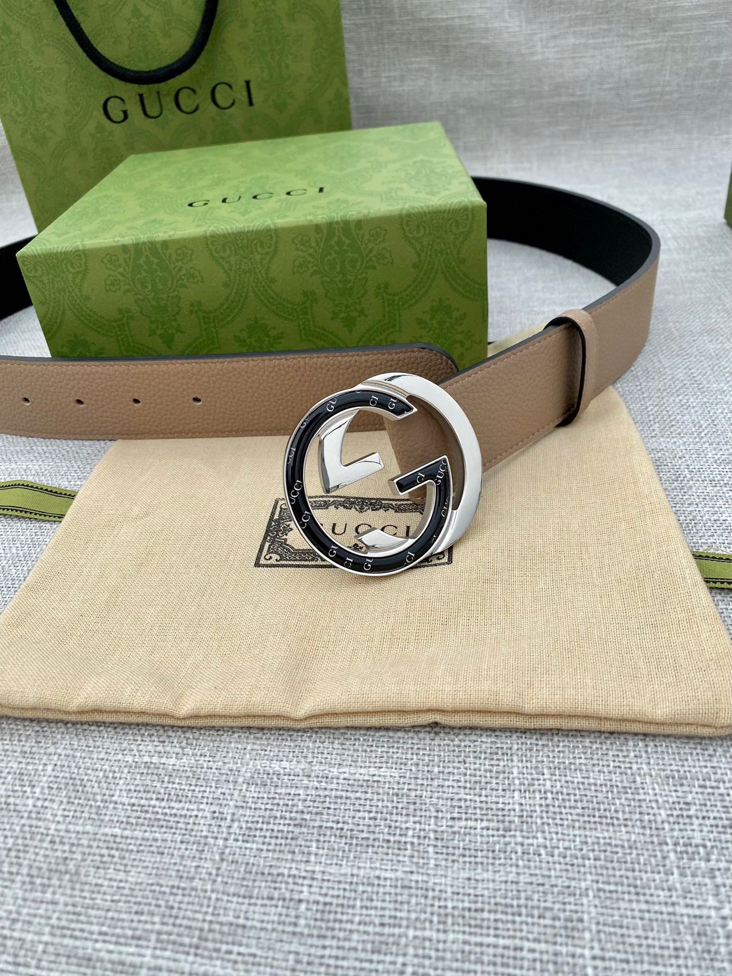 Beige leather belt with circular GG-logo buckle and keeper holes