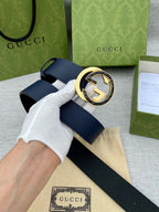 Navy leather belt with large round gold-tone GG buckle