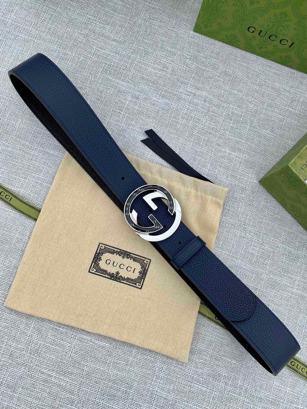 Navy leather belt with round silver-tone buckle and GG logo