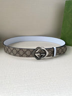 Gucci belt laying flat, beige-brown GG canvas with white edge and round interlocking G buckle