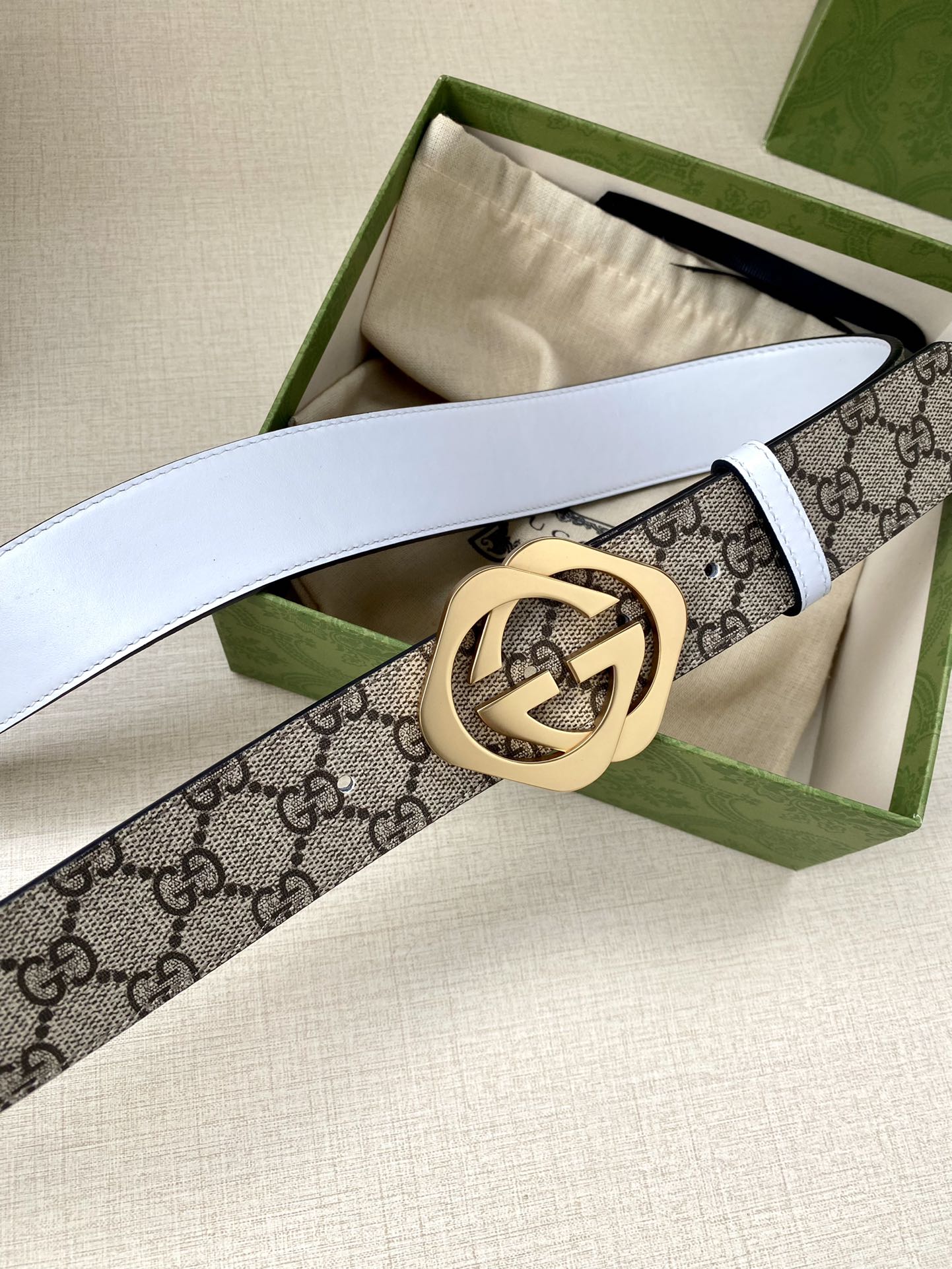 Gucci belt, GG monogram strap with round gold buckle, white leather underside