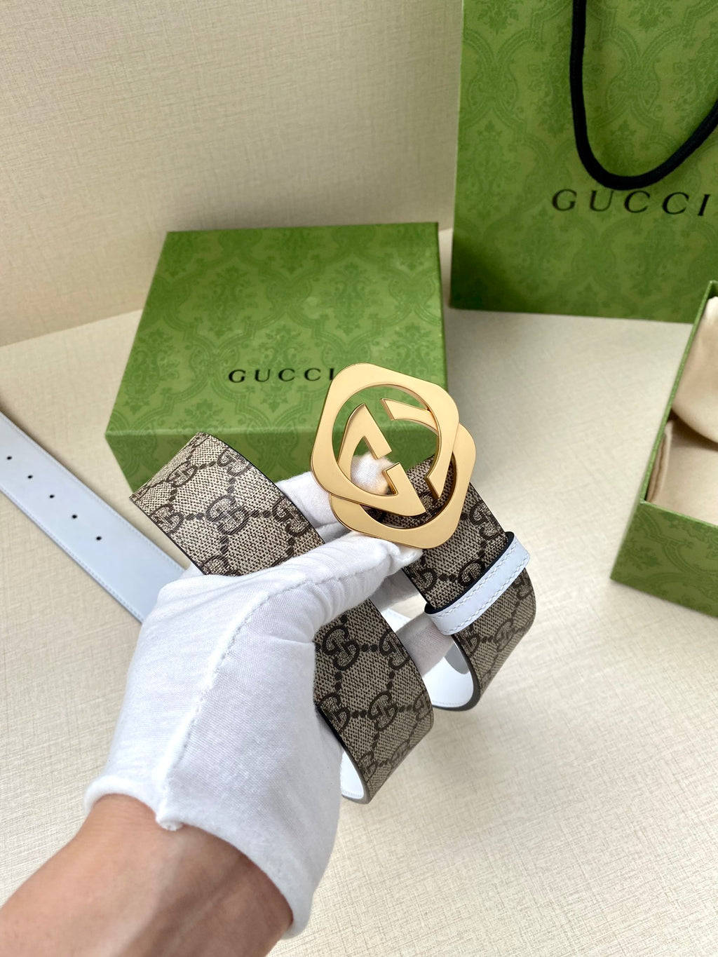 Gucci belt with GG monogram strap, gold interlocking buckle, white keeper strap