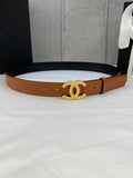 Tan leather belt with gold-tone interlocking CC buckle on a gift box