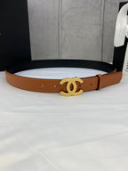Tan leather belt with gold-tone interlocking CC buckle on a gift box