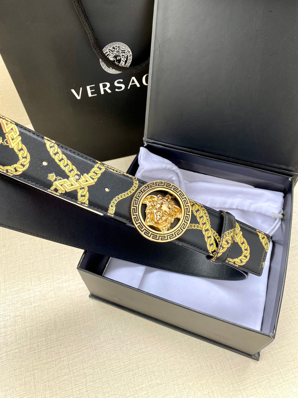 Navy patterned belt with gold medallion buckle on folded strap