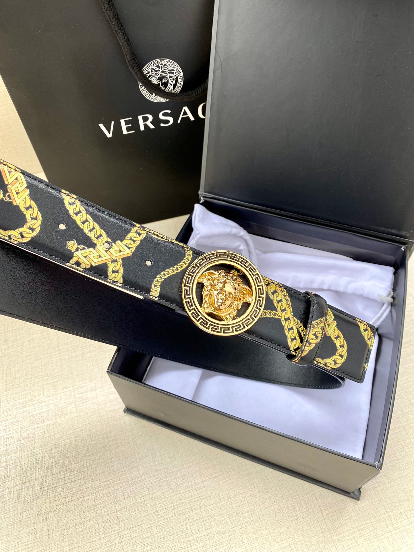 Navy patterned belt with gold medallion buckle on folded strap