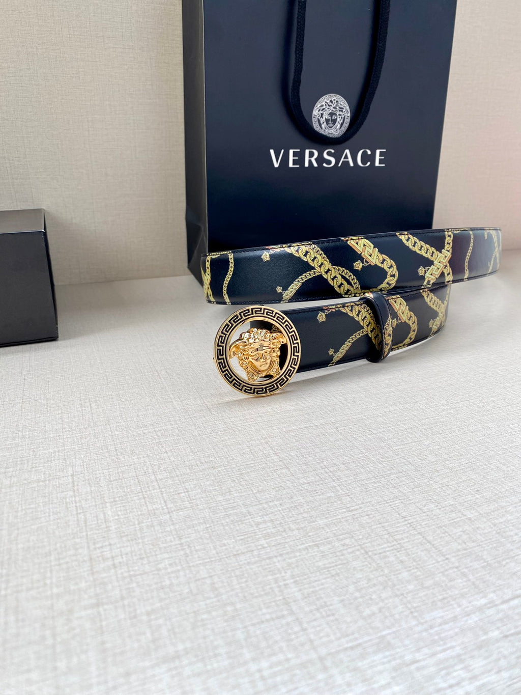 Navy belt with gold chain pattern and circular buckle with gold center