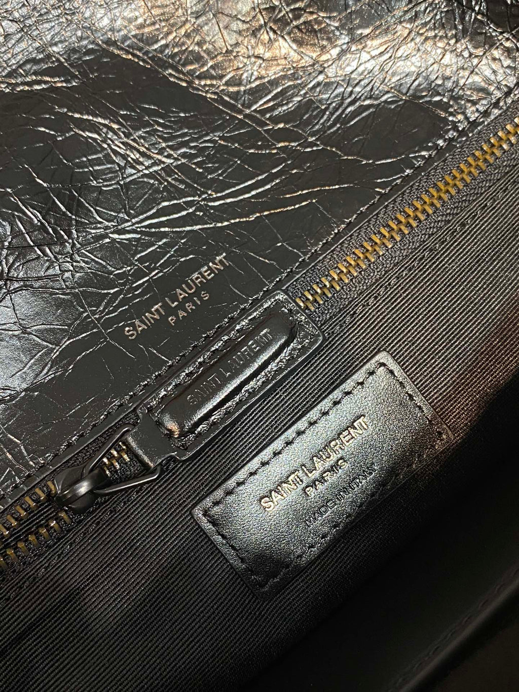 YSL Saint Laurent zipper pouch with embossed logo patch and metal pull on dark leather