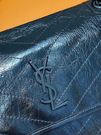 YSL Saint Laurent quilted flap with YSL monogram emblem on dark leather