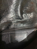Saint Laurent leather bag interior logo patch on dark lining