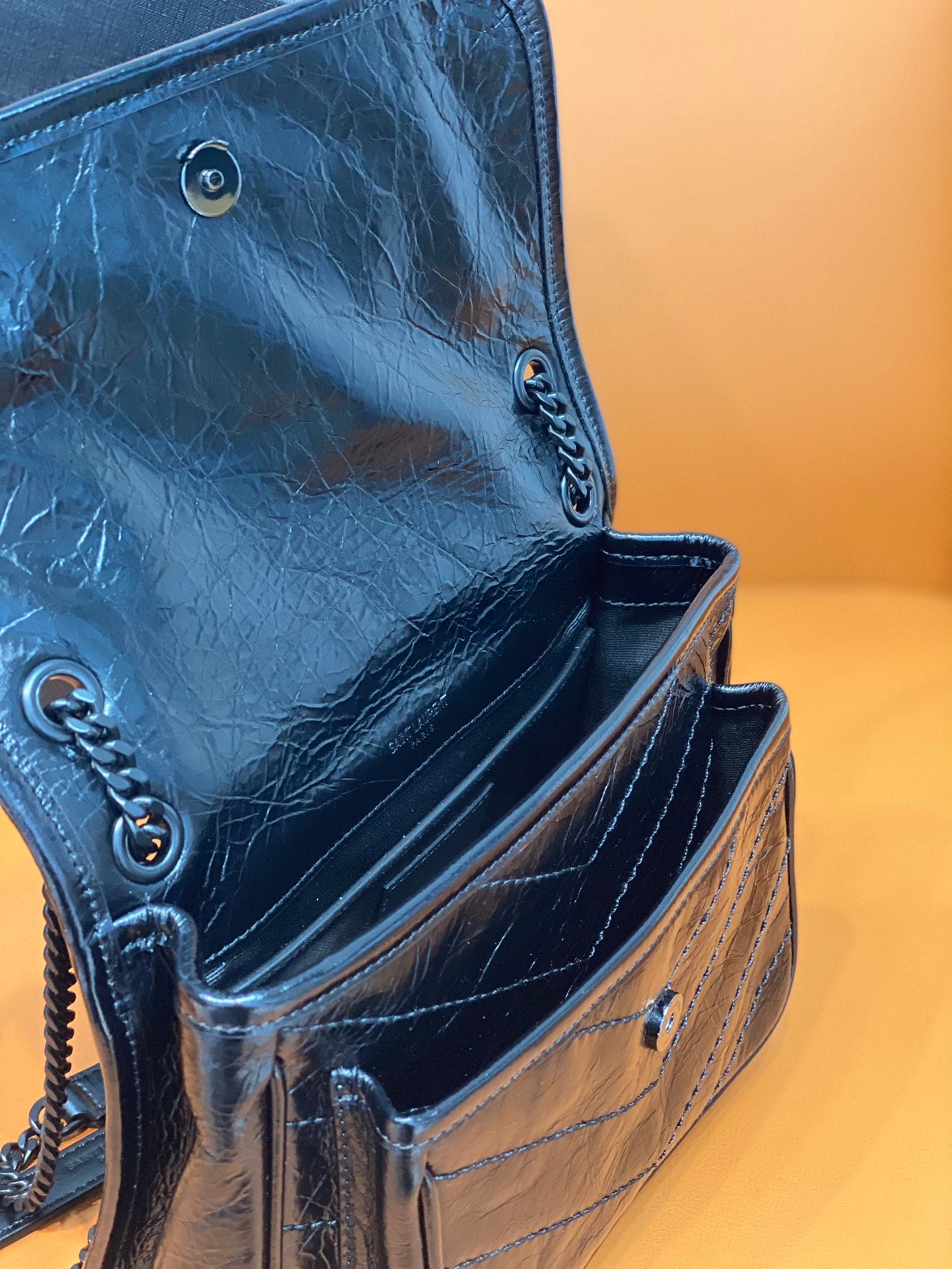 Saint Laurent blue leather crossbody bag side view with chain strap and snaps