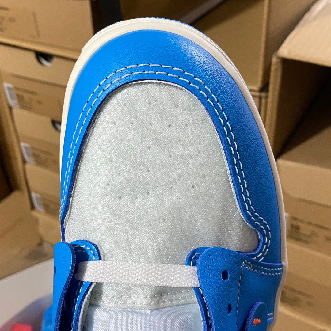 White toe box with blue collar trim and lace eyelets on a high-top sneaker.