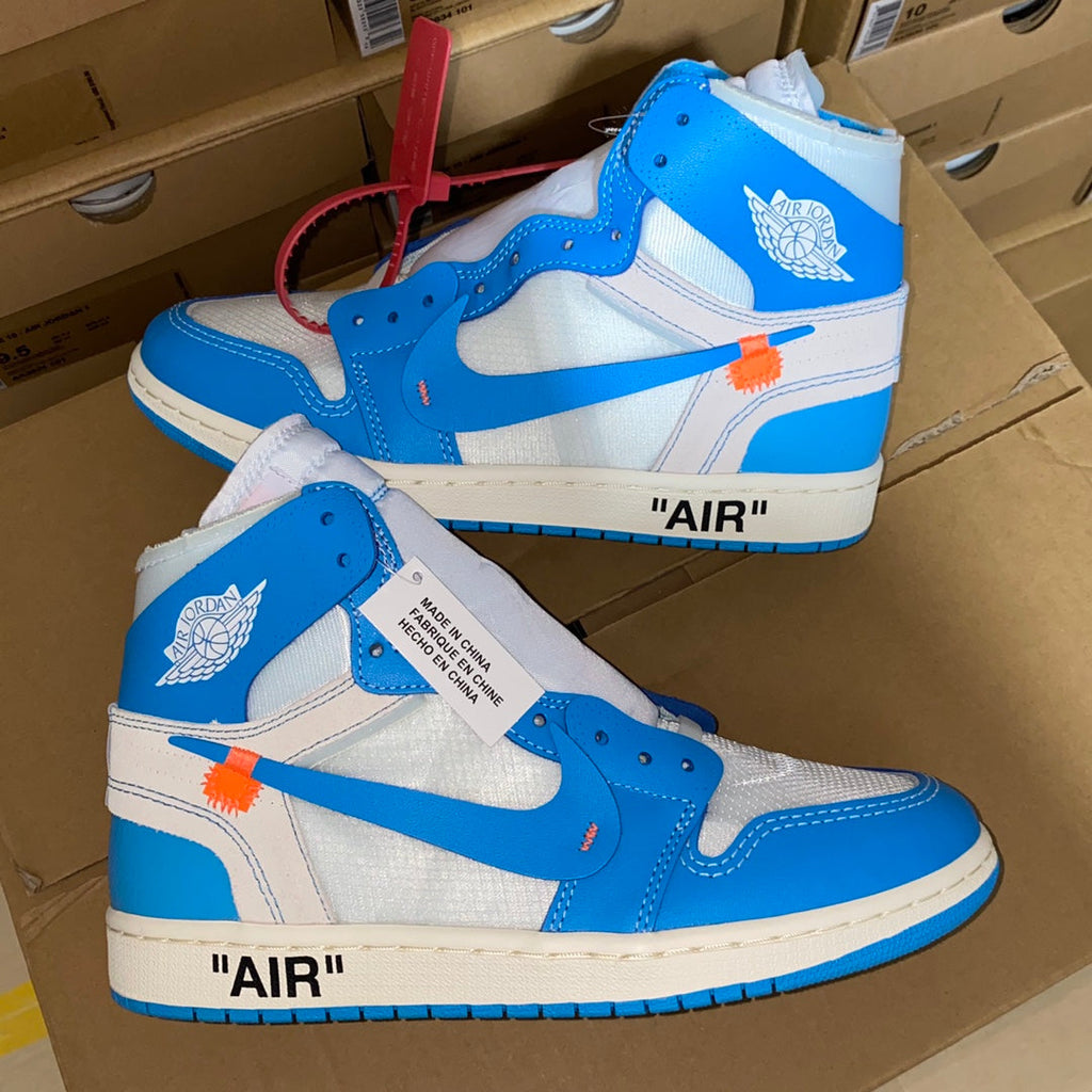 Pair of blue and white high-top sneakers with orange accent strap and Swoosh.