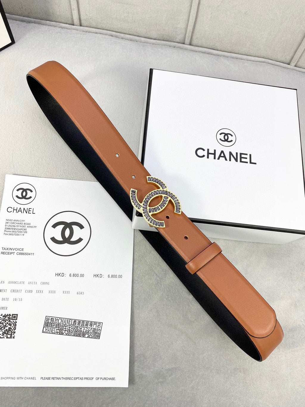 Chanel leather belt with tan front, black underside, and gold-tone interlocking CC buckle
