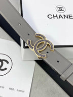 Chanel leather belt close-up: gray strap with gold-tone CC logo buckle and punch holes