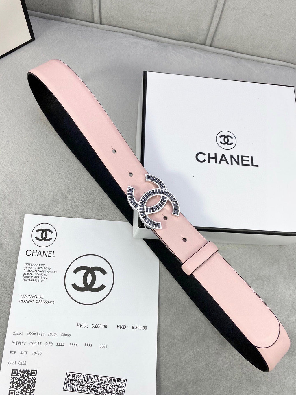 Chanel belt with pale pink leather strap and gold logo buckle over black lining