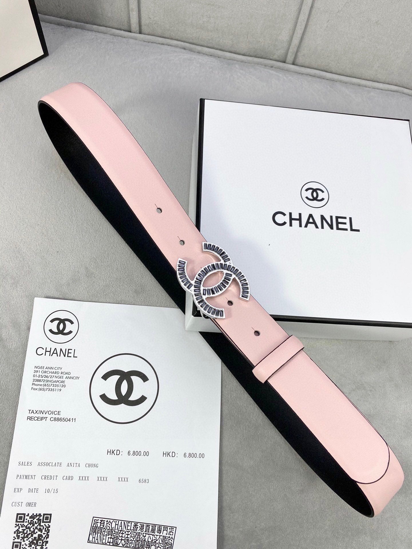 Chanel belt with pale pink leather strap and gold logo buckle over black lining