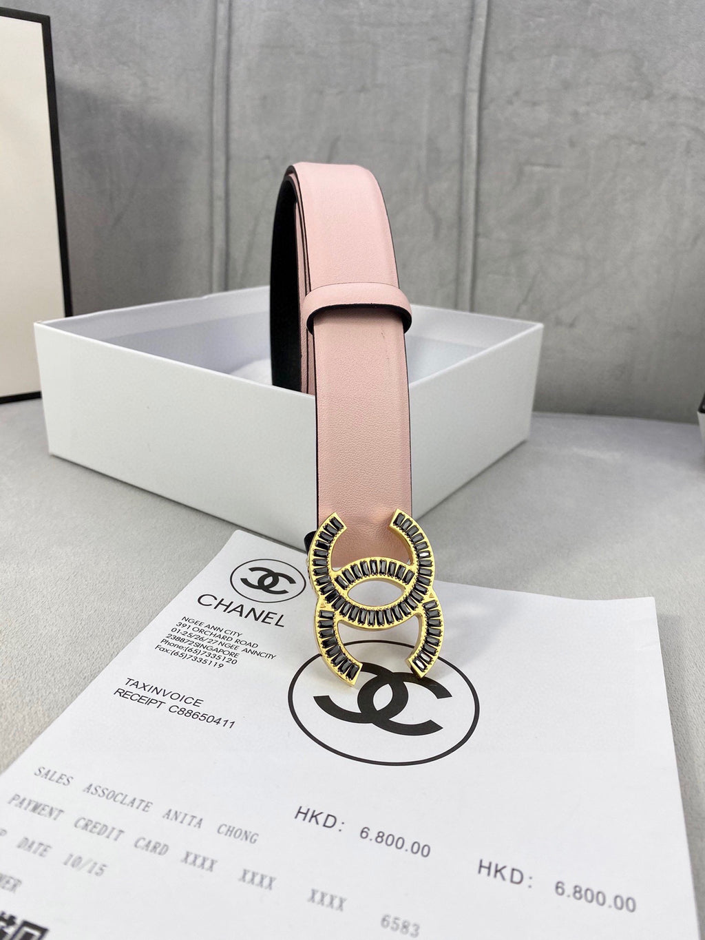 Chanel belt with pale pink leather strap and gold logo buckle, side view