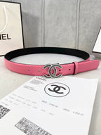 Chanel belt with pink leather strap and ornate oval CC buckle on black backing.