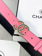 Chanel belt buckle detail: pink leather with silver CC medallion, red enamel center, holes.