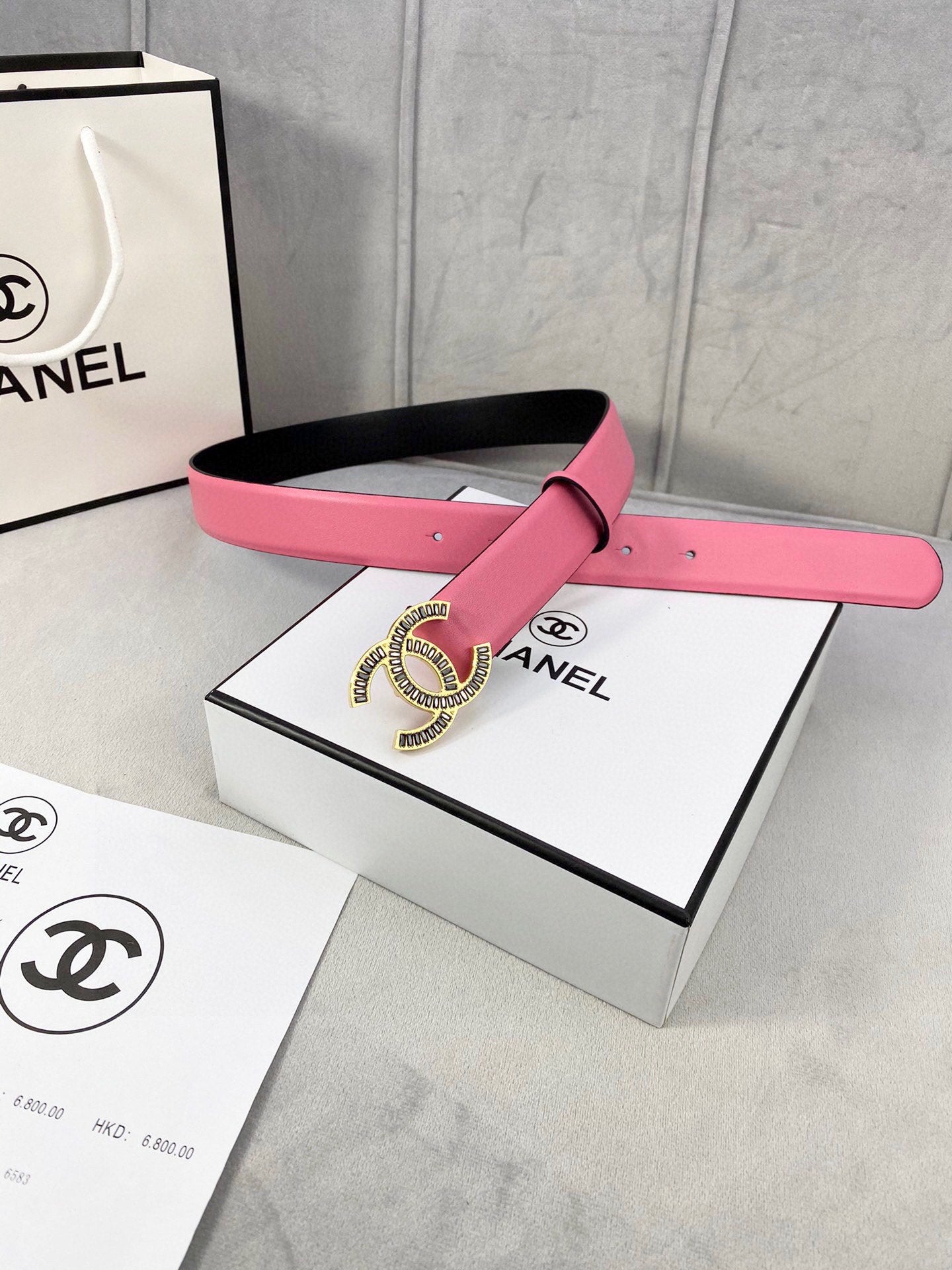 Chanel belt on box set: pink strap, silver CC medallion buckle, black backing strap.
