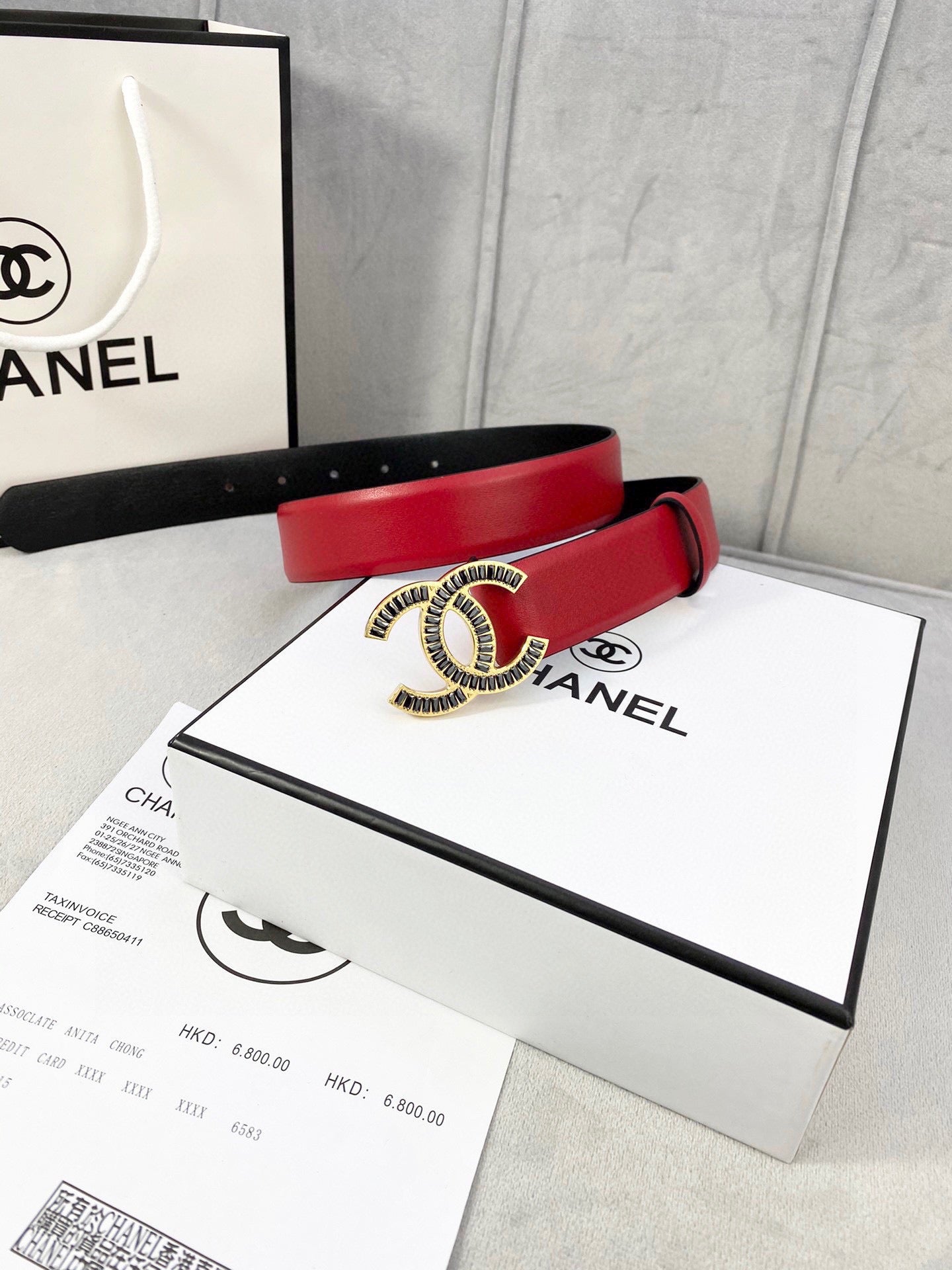 Chanel belt with red leather strap and CC logo buckle on display packaging