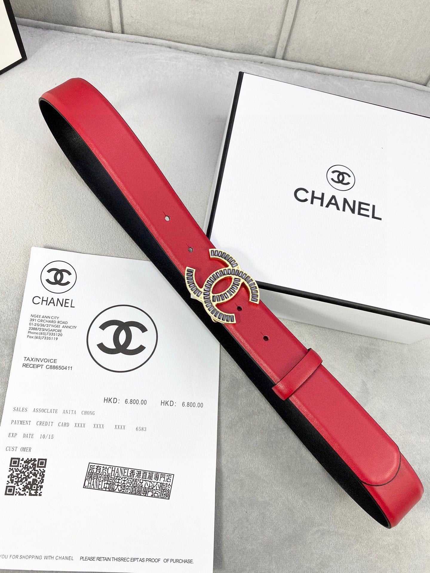Chanel belt showing red leather front and black underside with CC logo buckle