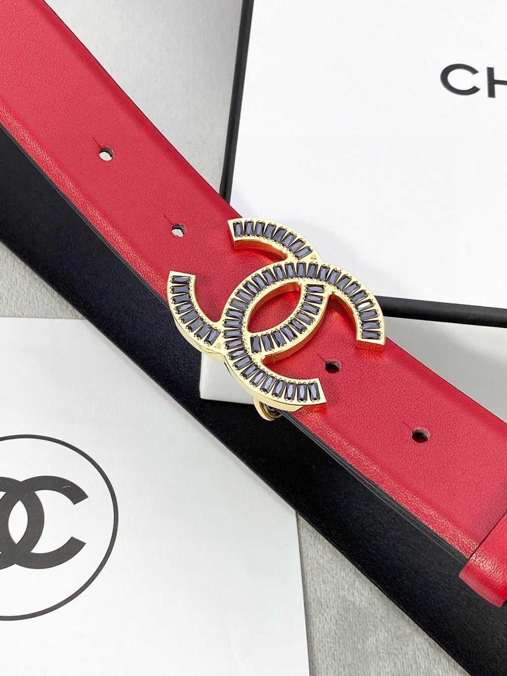 Chanel belt close-up: red leather with CC logo buckle and punched adjustment holes