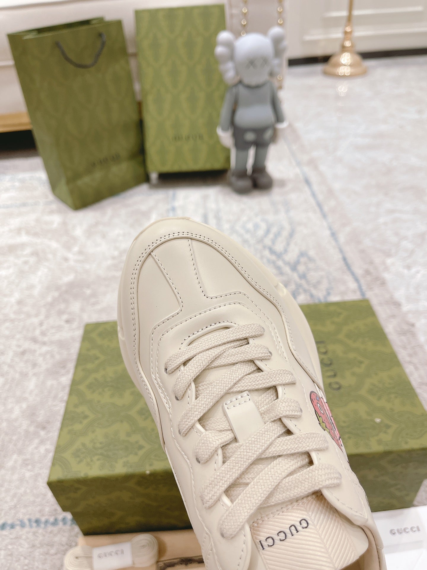 White leather sneaker close-up, laces and rounded toe with GUCCI branding