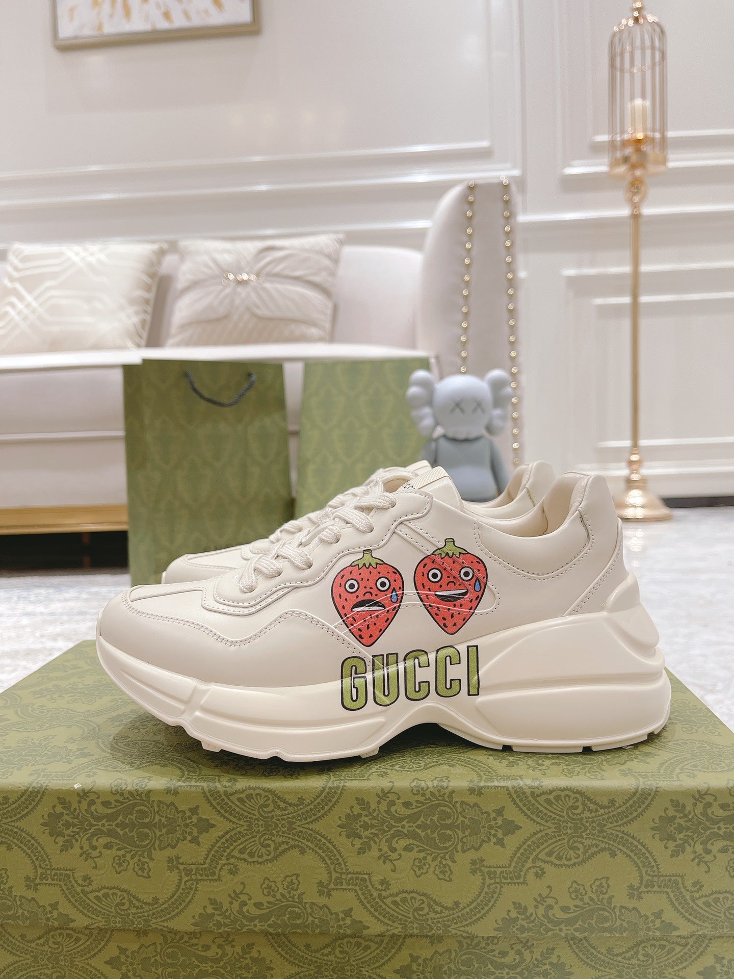 White leather lace-up sneakers with strawberry patches and GUCCI logo, side view