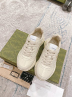 White lace-up Gucci sneakers with embossed logo on tongue and side panels