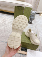 White Gucci sneaker outsole tread with grip pattern, with one shoe beside box