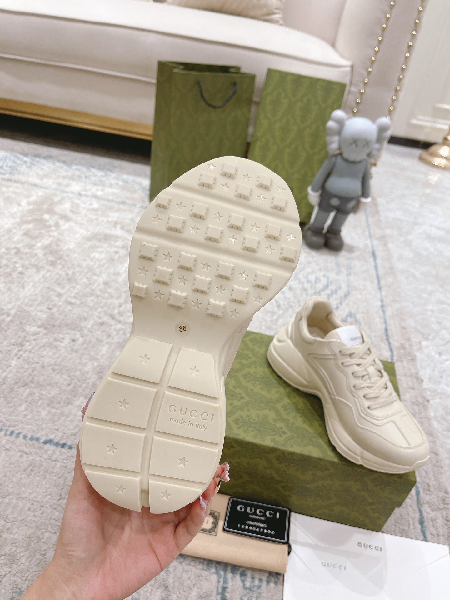 White Gucci sneaker outsole tread with grip pattern, with one shoe beside box