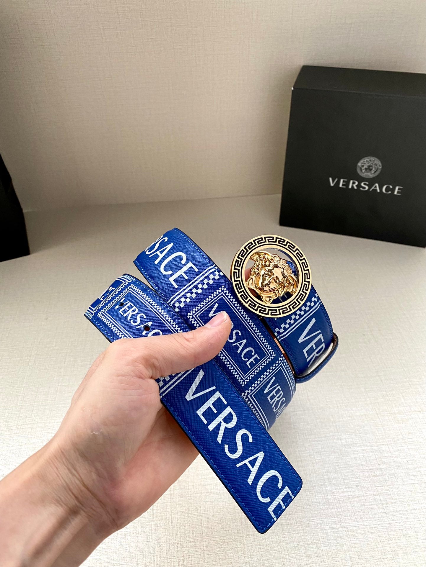 Versace belt folded: blue monogram strap with round gold medallion center buckle