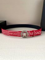 Versace belt laid flat with red logo strap and circular lion center buckle