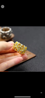 Gold-tone crystal-studded chrome ring held in hand