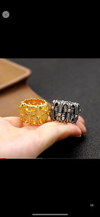 Two chrome rings held in a hand: gold-tone and blackened silver-tone